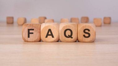 Ahşap yüzeyinde 'FAQS' harfleri olan tahta küpler. Sıklıkla sorulan sorular, müşteri desteği, çevrimiçi yardım, sorun çözme, bilgi tabanı, iş yardımı ve sorun çözme kavramı.