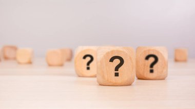 Odak noktasında siyah soru işaretleri olan üç küp şüphe, merak ve karar verme mekanizmasını temsil ediyor. Ek bloklarla bulanık arkaplan belirsizlik ve stratejik düşünme temasını geliştirir