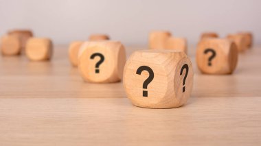 Açık gri zemin üzerinde soru işaretleri olan üç tahta küp fotokopi alanı, çözülme