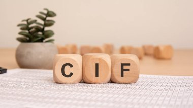 Küresel ticaret, tedarik zinciri yönetimi, uluslararası taşımacılık ve ticari işlemleri sembolize eden, finans belgelerine yerleştirilmiş CIF 'nin tahta küpleri.