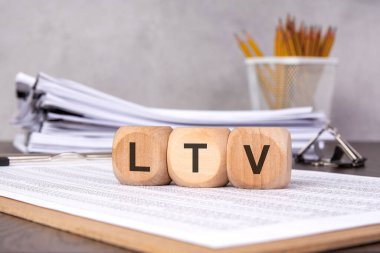 LTV gösteren üç tahta küp, iş ve pazarlamada kilit bir ölçü olan Müşteri Yaşam Değeri 'ni sembolize ediyor. veri analizi vurgulanıyor.