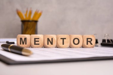 Kılavuz, koçluk ve kariyer desteğini temsil eden kağıt işleriyle uğraşan ahşap küplere. Kalem ve kalemle yapılan ofis ortamında liderlik ve profesyonel danışmanlık üzerinde duruluyor.