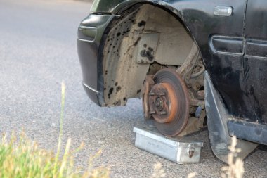 Hasarlı çamurluk ve kirli tekerlek hırsızlığı, kazayı ya da mekanik sorunları gösteriyor. Görüntü araba tamiri, bakım sorunları, yol kenarı sorunları veya araç terk etme temalarını iletir.
