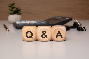 Q A Soruları ve Cevapları açık renkli bir ofis masasına yerleştirilmiş harfleri gösteren küpler. Müşteri desteği, iletişim, çevrimiçi yardım bölümleri ve kurumsal FAQ 'lar gibi konular için ideal.