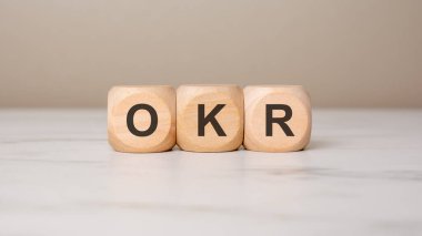 Tahta bloklar O, K ve R harfleriyle mermer yüzeydeki hedefleri ve anahtar sonuçları simgeliyor.