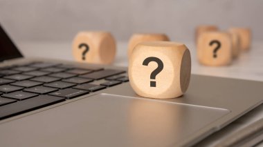 Laptop klavyesinde soru işareti olan tahta blok, yardımı, SQ 'yu veya dijital veya iş bağlamında sığ bir alan derinliğine sahip bir soruşturmayı sembolize ediyor