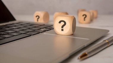Laptop klavyesinde soru işareti olan tahta blok, yardımı, SQ 'yu veya dijital veya iş bağlamında sığ bir alan derinliğine sahip bir soruşturmayı sembolize ediyor