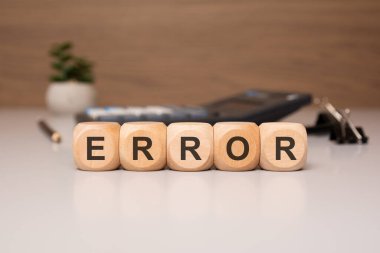 HATA kelime temiz bir masa üzerinde ahşap bloklar, bir hesap makinesi ve kırtasiye yumuşak odaklı kırtasiye ile hecelenir