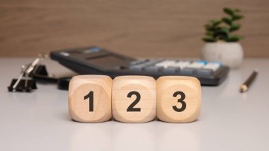 1, 2 ve 3 numaralı sayıları gösteren üç tahta küp. İşletme bağlamında sıralamayı, öncelikleri ya da adımları simgeliyor.