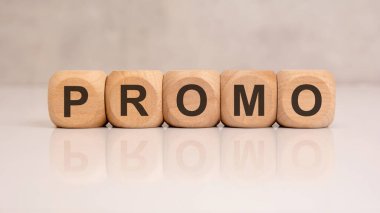 Parlak beyaz masa yüzeyinde ProMO harfleri olan tahta küpler pazarlamayı, indirimi, reklamcılığı ve iş tanıtımını sembolize ediyor.
