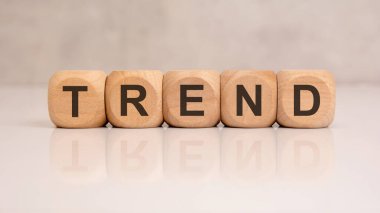 wooden blocks forming the word TREND on reflective surface. Concept of subject, theme, discussion, conversation, education, or business presentation.