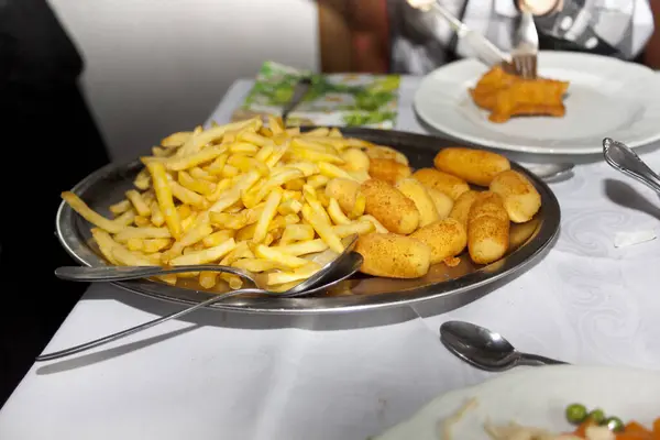 French fries and croquettes on plate in restaurant isolated