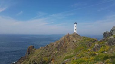 Rocky Cliff 'teki Iconic Lighthouse' la nefes kesici Kıyı Manzarası Açık Gökler Altında Uçsuz bucaksız Mavi Okyanusa Bakıyor