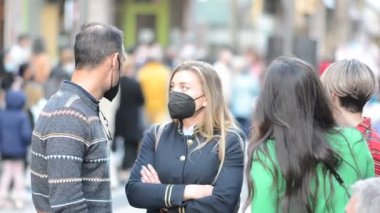 Kara Maskeli Genç Kadın Yoğun Şehir Caddesinde Dikkatsiz Yolcularla Sohbet Ediyor
