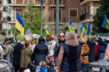 Bir şehir meydanında Ukrayna bayrakları ve protesto işaretleri taşıyan kalabalık dayanışma ve barış talep ediyor. Ukrayna 'yı destekleyen duygusal toplantı.