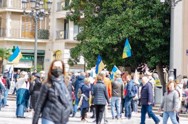 Bir grup insan barışçıl bir protesto için Avrupa şehir meydanında toplanarak Ukrayna bayrakları sallıyor ve dayanışma gösteriyorlar. Kentsel aktivizm ve Ukrayna 'ya destek.