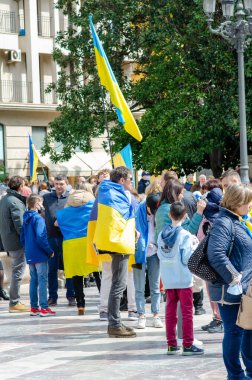 Bir grup insan Ukrayna bayraklarına sarılı bir şehir meydanında protesto yapıyor ve Ukrayna 'ya halk gösterileri sırasında destek ve dayanışma gösteriyorlar..