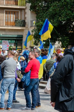Ukrayna 'yı destekleyen barışçıl bir miting. Elinde mavi ve sarı bayraklar ve pankartlar olan insanlar. Kentsel bir ortamda özgürlük ve sosyal adalet için duygusal bir gösteri..