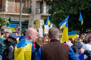 Göstericiler, savaş karşıtı miting sırasında ellerinde Ukrayna bayrakları ve protesto pankartları tutarak, canlı bir şehir ortamında Ukrayna ve barışa destek ifadesinde bulundular..
