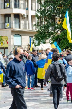 İnsanlar bir şehir meydanında Ukrayna bayrakları sallayarak barışçıl bir protesto sırasında birlik ve destek gösteriyorlar. Bu gündüz mitinginde kentsel aktivizm ve dayanışma ele geçirildi.