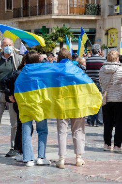 Halk meydanında toplanan kalabalık, barışçı bir gösteri sırasında ulusal bayrakları sergileyerek Ukrayna 'ya destek ve birlik gösteriyor. Duygusal ve destekleyici atmosfer.