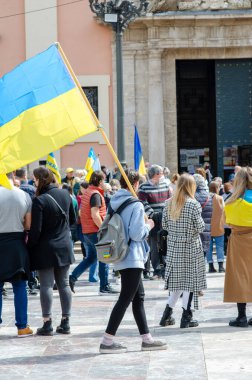 Ukrayna 'yı destekleyen barışçıl bir gösteriye katılan bir kalabalık, tarihi bir şehir merkezinde Ukrayna bayrakları taşıyor. Vatansever ve sivil birlik.