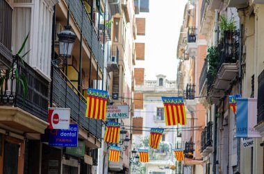 Valencia 'daki renkli bölgesel bayrakları, geleneksel balkonları ve şenlikli şehir atmosferiyle büyüleyici İspanyol caddesi seyahat ve kültür kavramları için mükemmel..