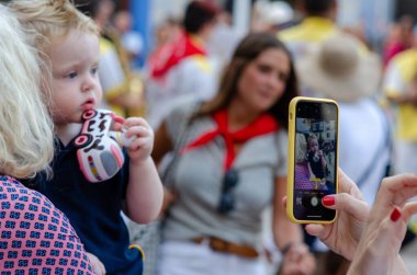 Küçük bir çocuk oyuncak dondurmayla neşeli bir anın tadını çıkarırken, birisi canlı bir sokak festivali sırasında akıllı telefonuyla anıları yakalıyor. Kentsel aile etkinliği, gizli yaşam tarzı.