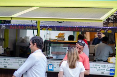 Canlı bir yemek kamyonundan yemek ısmarlayan insanların olduğu şehir sahnesi. Sokak yiyecekleri kültürü, günlük etkileşim ve yaz atmosferi şehir pazarında yakalandı..