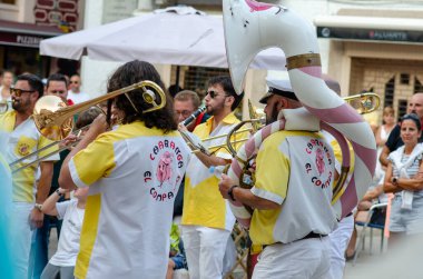 Neşeli bando, canlı bir açık hava festivali sırasında sokak seyircilerini eğlendirip renkli üniformalar ve canlı müzik performanslarıyla neşeli bir atmosfer yaratıyor..