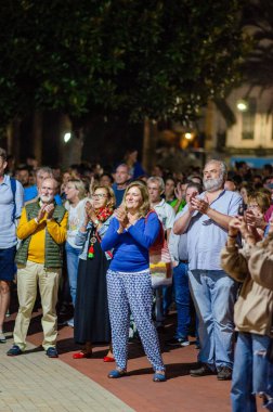 Şehirdeki bir açık hava etkinliği sırasında alkış tutan seyirciler, halka açık bir toplantıya neşe, birlik ve toplum katılımı gösterdiler..