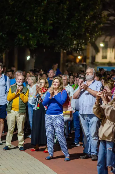 Şehirdeki bir açık hava etkinliği sırasında alkış tutan seyirciler, halka açık bir toplantıya neşe, birlik ve toplum katılımı gösterdiler..