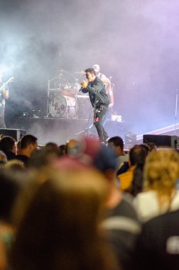 Coşkulu hayranlar ve dramatik sahne ışıklandırmasıyla bir müzik festivalinde sahne alan bir rock grubunun coşkulu sahnesi, canlı tanıtımlar için mükemmel..