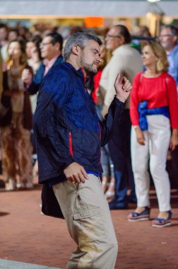 Neşeli bir adam, insanlarla çevrili canlı bir açık hava toplantısında dans etmekten hoşlanır. Kentsel yaşam tarzı ve gece sosyal ortam bu samimi anda yakalanır..