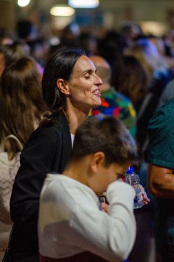 Kapalı bir sosyal etkinlikte yetişkinlerin ve çocukların samimi anı. Kalabalık içinde doğal duygular ve canlı iletişim, toplum ve yaşam tarzı kavramları için mükemmel..