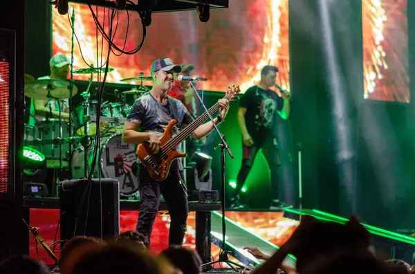 Sahnede müzisyenlerin sahne aldığı enerjik rock konseri, dinamik ışıklandırma efektleri ve canlı bir atmosfer. Müzik, etkinlik ve gece hayatı temaları için mükemmel.