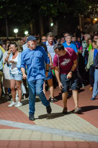 Canlı bir gece sokak festivalinde yürüyen ve sosyalleşen enerjik bir grup insan neşeli bir şehir topluluğu toplantısı ve şenlikli bir atmosfer yakalıyor..