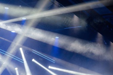 Işık ve atmosferik sis dinamik kirişleri bir konser salonunda enerjik bir parti havası yaratarak, canlı sahne aydınlatma efektlerini ve gece kulübü ambiyansını vurguluyor..