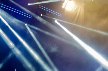 Sahne ışıklarının dinamik ışınları bir konserde dumandan parlayarak canlı bir atmosfer yaratıyor. Müzik etkinlikleri ya da eğlence temaları için mükemmel.