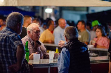 İki son sınıf öğrencisi, neşeli bir festival kalabalığıyla çevrili hareketli bir gece barında içki içip sohbet etmekten zevk alarak neşeli ve sıradan bir gece ortamı yaratıyor..