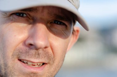 Açık renk şapkalı orta yaşlı bir adamın açık havada, gün ışığında doğal duygularını göstermesi etkileyici. Macera, seyahat ve yaşam tarzı kavramları için mükemmel..