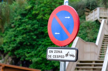 Çimenli bir bölgede, yemyeşil ve açık hava ahşap basamaklarına karşı çekilen araba uyarısı olan bir İspanyol 'a yakın çekim yapmak yasak. Ulaşım veya işaret teması için harika.