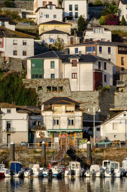 Geleneksel Akdeniz köyü. Katmanlı evler ve öğleden sonra manzaralı balıkçı tekneleri, canlı mimari ve barışçıl kıyı atmosferiyle..