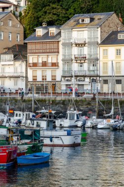 Limana yanaşmış balıkçı tekneleri ve tarihi konut binaları olan Avrupa kıyı kasabasının sahili. Seyahat ve turizm kavramları için mükemmel..