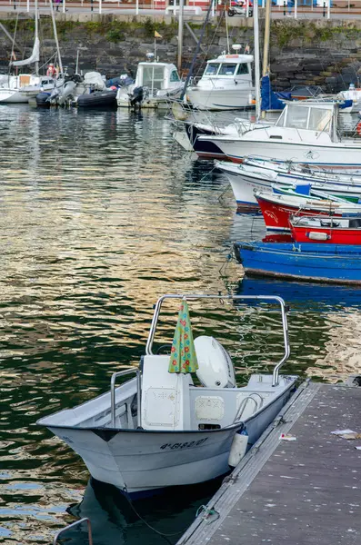 İskeleye demirlemiş birkaç teknesi olan huzurlu bir liman, akşam sularını yansıtıyor. Huzurlu atmosfer ve deniz yaşam tarzı, seyahat temaları için ideal.