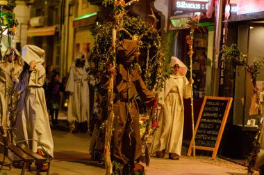 Bir İspanyol Cadılar Bayramı karnavalında gece sokak sahnesi. Festivalde kapüşonlu cüppeli ve doğadan esinlenilmiş kostümlü insanlar olacak. Cadılar Bayramı, İspanyol karnavalı.