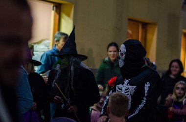 Şenlikli kalabalık, İspanya 'da cadılar bayramı karnavalı düzenliyor. Cadı ve iskelet kostümleri giymiş insanlar yerel gelenekleri ve canlı atmosferi kutluyor..