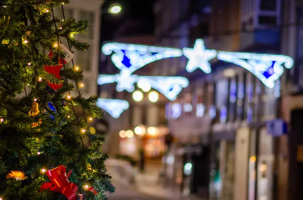 Şehir sokaklarında parıldayan süslerle süslenmiş güzel bir Noel ağacı. Canlı tatil ışıklarıyla aydınlatılmış. Şenlikli bir kış ortamı yaratıyor..
