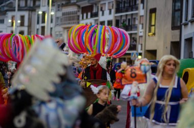 Yaratıcı kostümler içinde yetişkinler ve çocukların bulunduğu karnaval geçidi, canlı balon süslemeleri ve neşeli şehir atmosferi. Etkinlik ya da kutlama temaları için mükemmel.