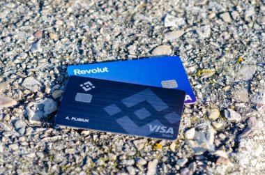 Modern banka kartları Revolut ve Binance Visa kaba asfaltta yatıyor, dijital finans, ödemeler ve sokak yaşam tarzını sembolize ediyor.